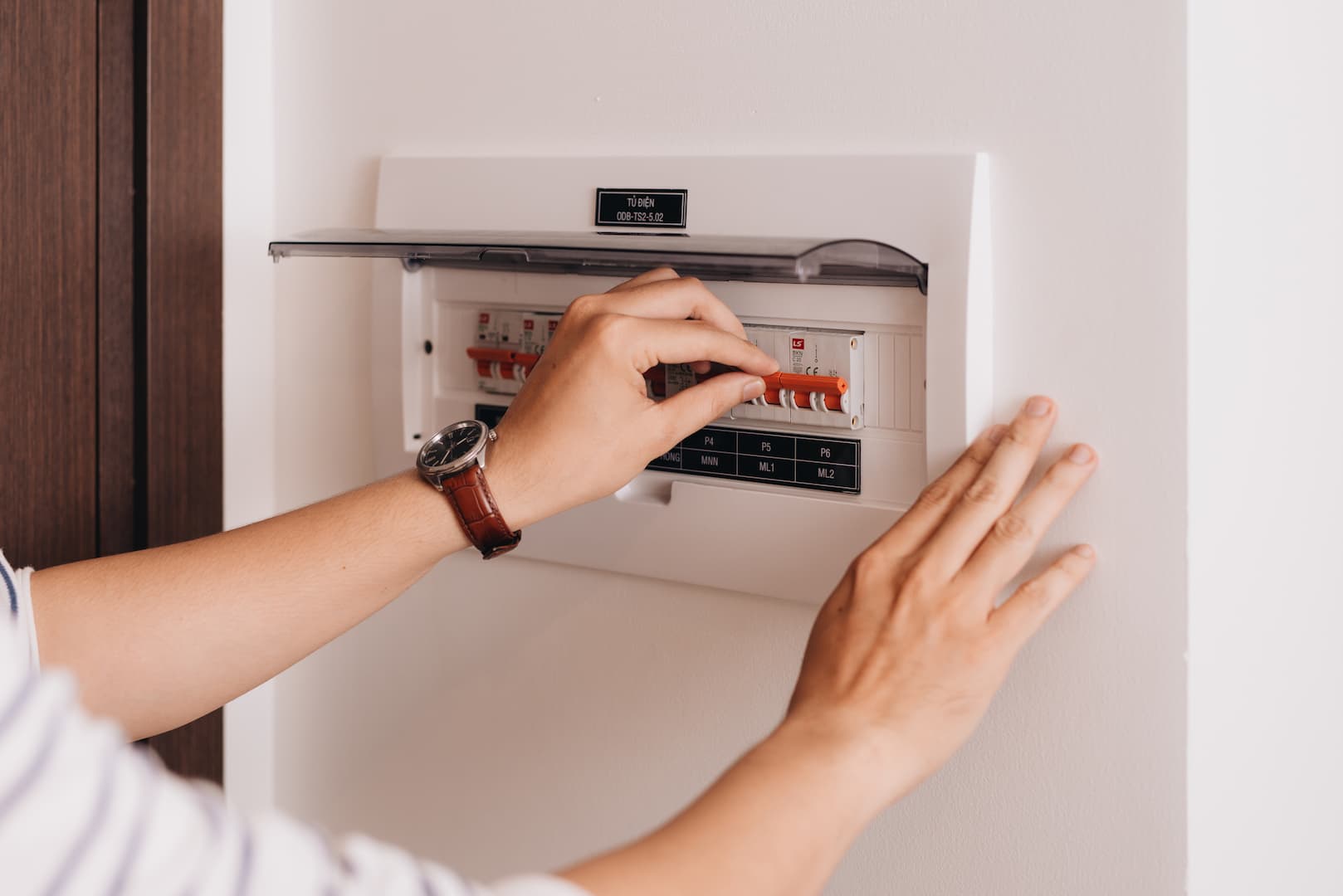 Person Checking Switches On Fuse Box